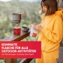 Evocamp Gaskartusche mit Campingkocher und Frau beim Outdoor-Kochen.