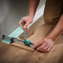 Wolfcraft Einpass-Set für Laminat: Handwerker zeichnet Laminat mit Einpasser an Wand an.