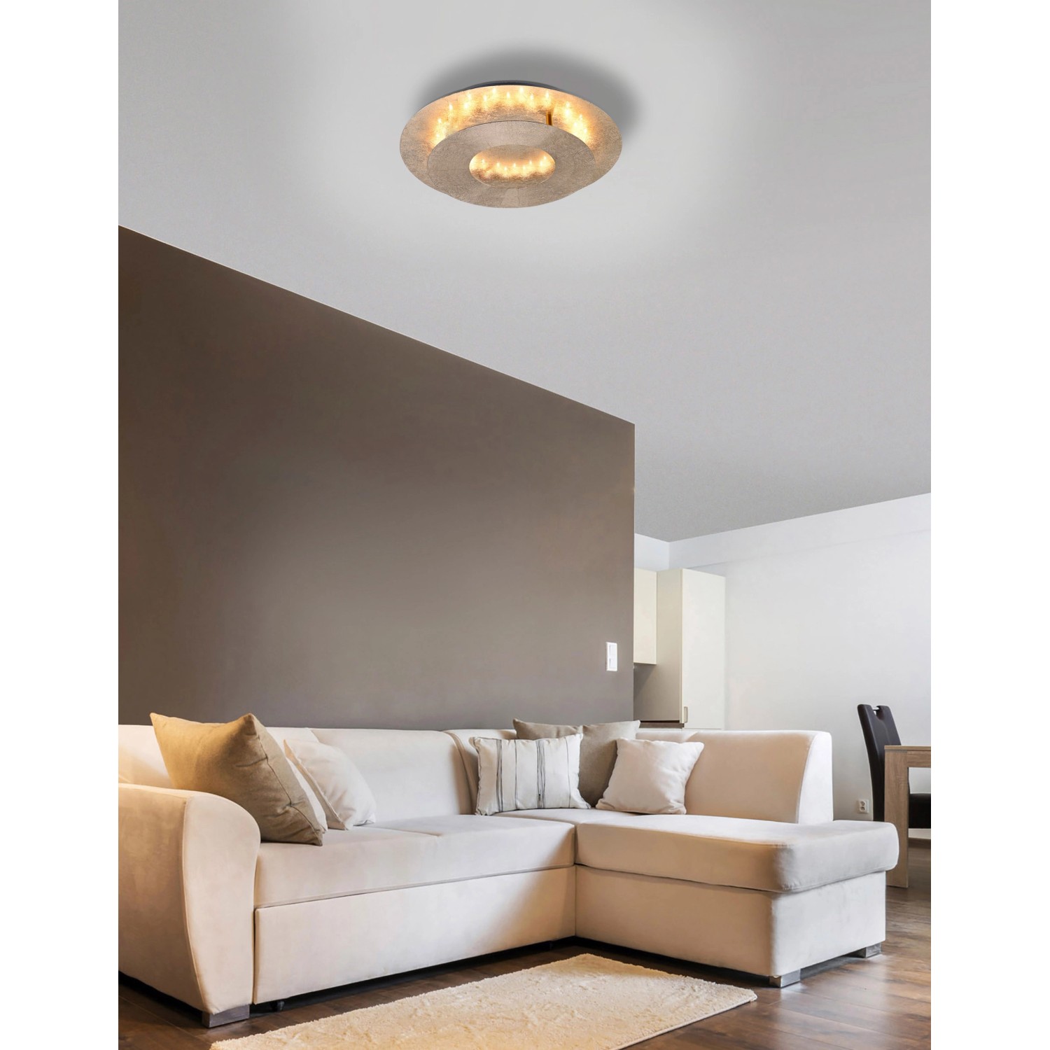 Goldene LED-Wandleuchte Nevis von Paul Neuhaus, 34x25,5 cm, im Wohnraum.
