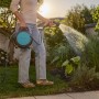 Frau bewässert Garten mit Gardena Schlauchbox Move 10 m. Mobiler Gartenschlauchwagen mit Spritze.