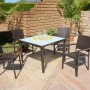 Garten Pleasure Stapelstuhl Malaga aus Aluminium, braunes Kunststoffgeflecht, mit Gartentisch und Dekoration.