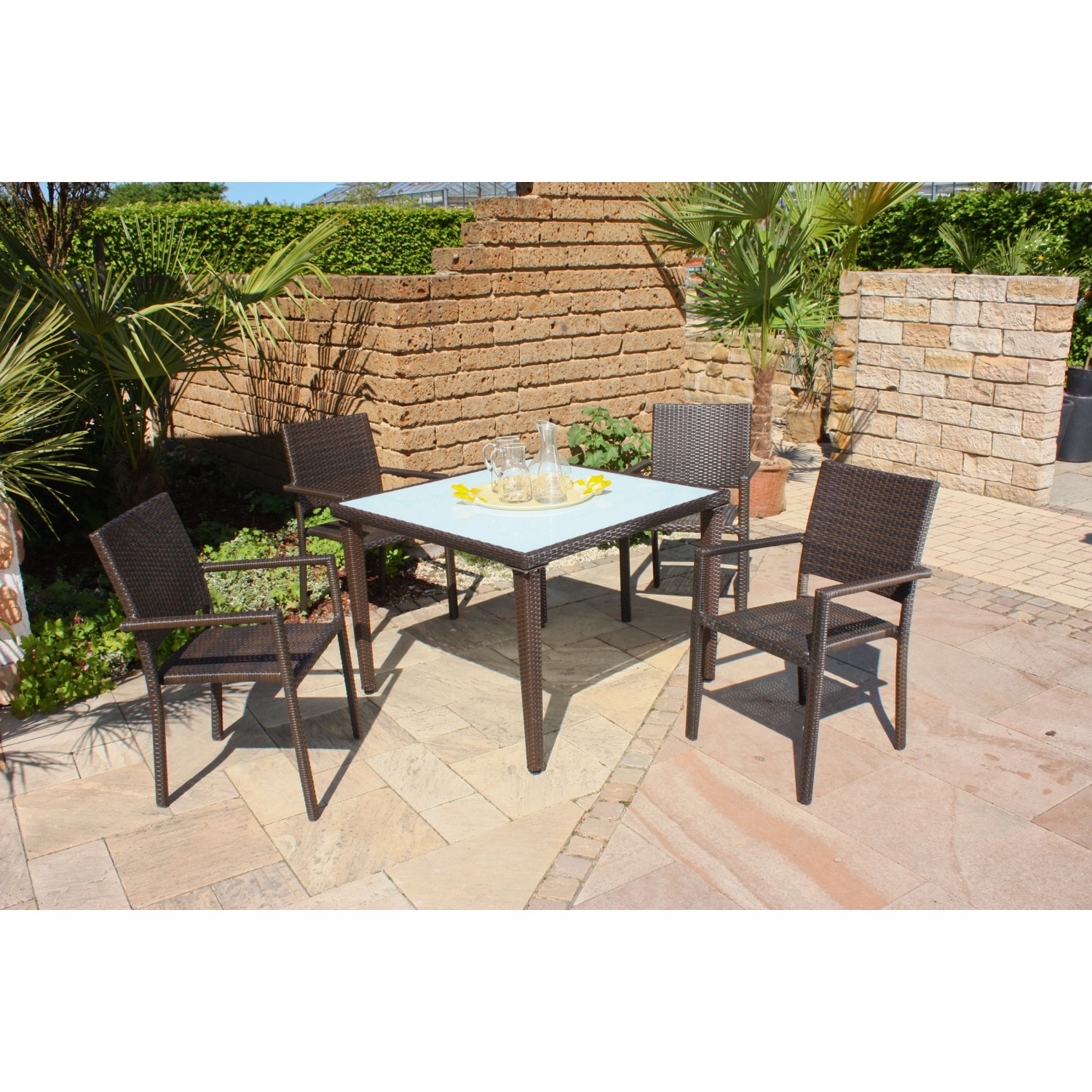 Garten Pleasure Stapelstuhl Malaga aus Aluminium, braunes Kunststoffgeflecht, mit Gartentisch und Dekoration.