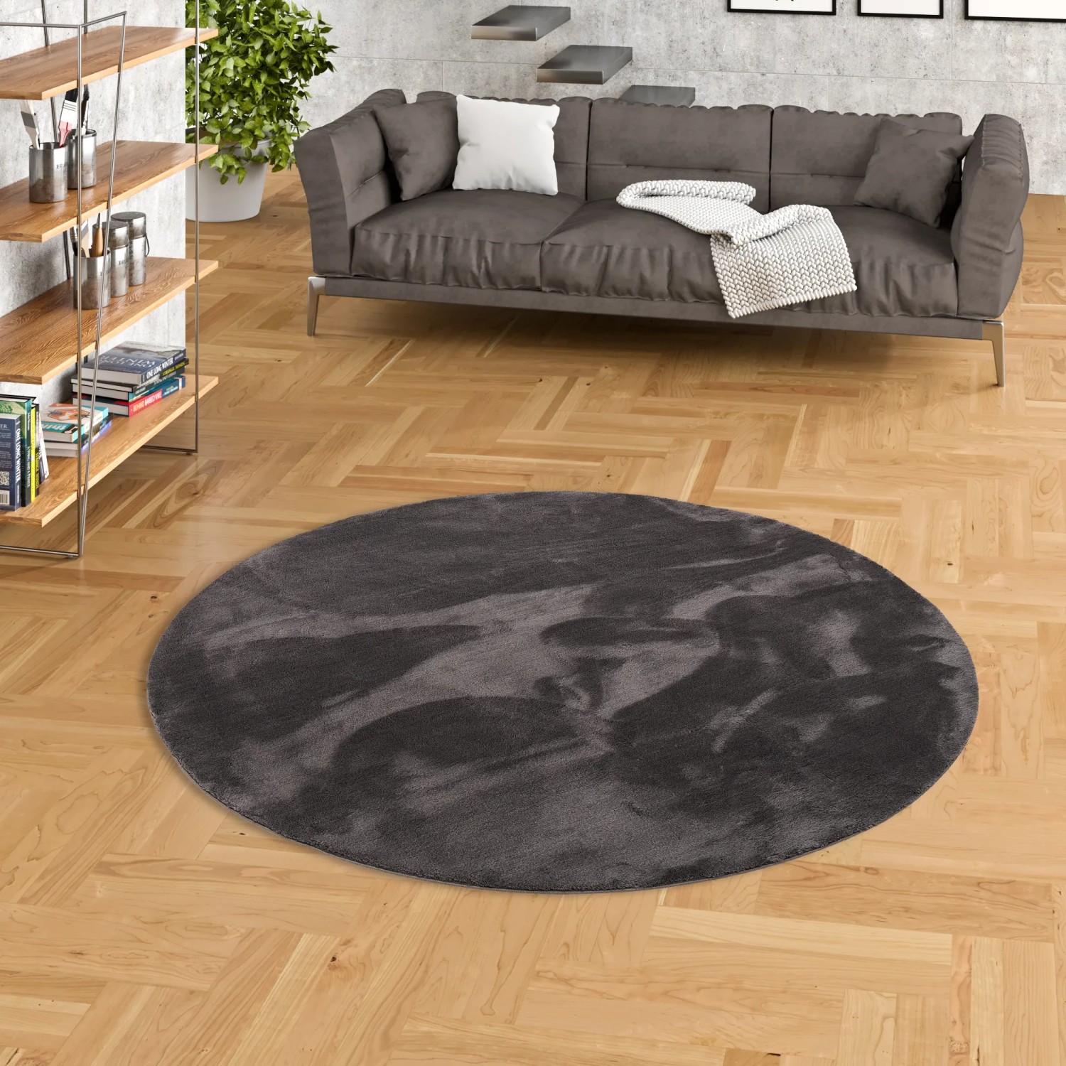 Runder, anthrazitfarbener Fellteppich „Pergamon Luxus Super Soft“ (160x160cm) auf Parkettboden.