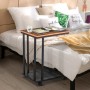 HOMCOM Beistelltisch in C-Form, schwarz/walnuss, mit Metallgestell und Rollen neben einem Bett.