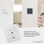 Homematic IP Schaltaktor 2-fach für Markenschalter. Modul und zwei integrierte Schalter (weiß, dunkelgrau) an der Wand.