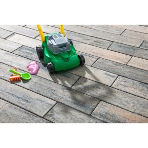 Diephaus Terrassenplatte Langas Muschelkalk mit Spielzeugrasenmäher und Förmchen.