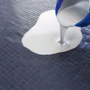 Knauf Kleber- und Boden-Elast wird aus einem blauen Eimer auf einen gefliesten Boden gegossen.