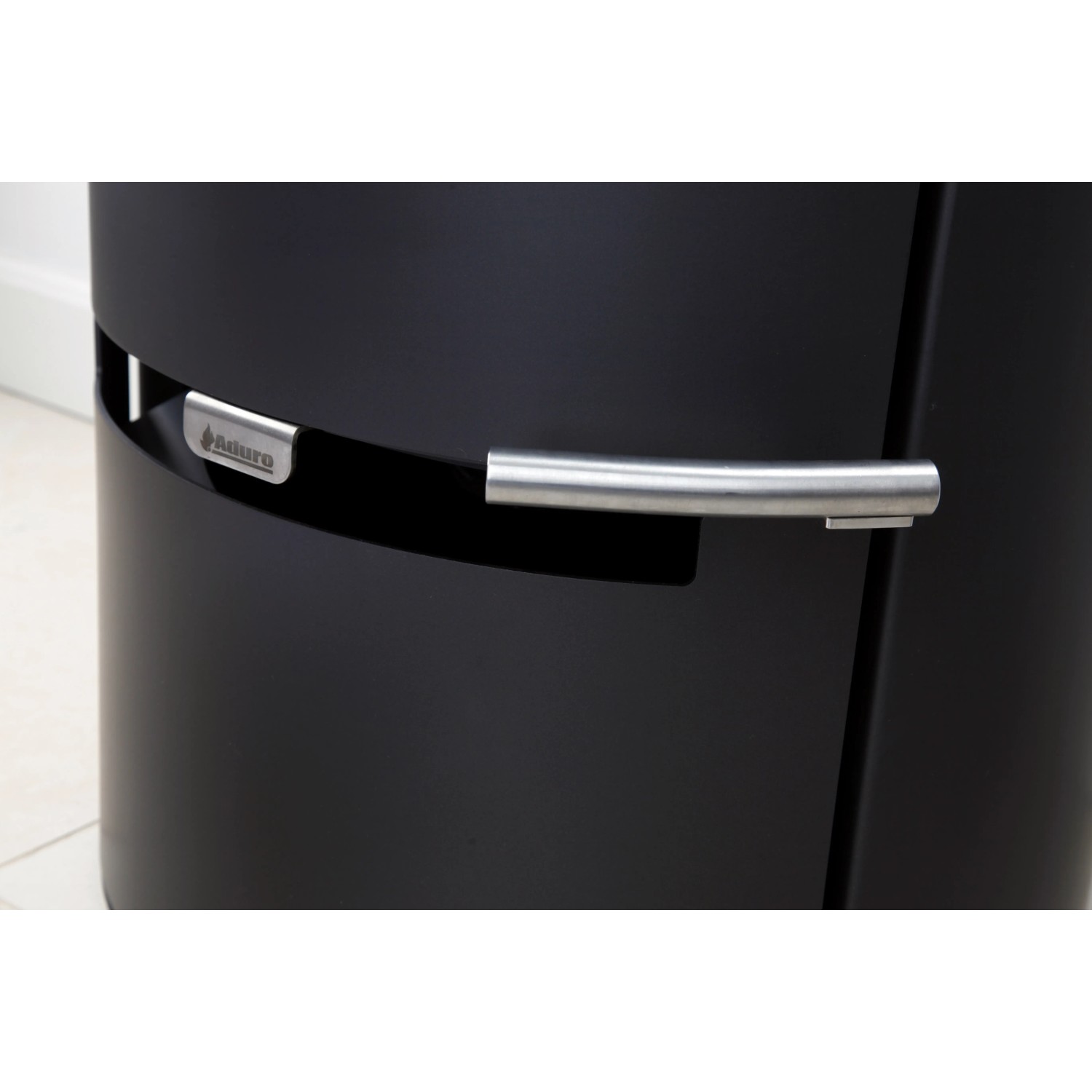 Detailaufnahme: Schwarzer Aduro 9.3 Kaminofen mit Stahlverkleidung und silbernem Griff.