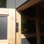 Detailaufnahme Gartenhaus Bertilo HPL 2 Italian Walnut: Tür mit Beschlag und Holzrahmen.