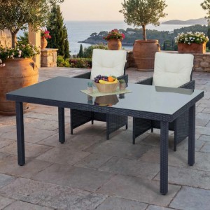 Rechteckiger MCW Poly-Rattan Gartentisch Chieti Anthrazit mit dunkler Glasplatte auf einer sonnigen Terrasse.