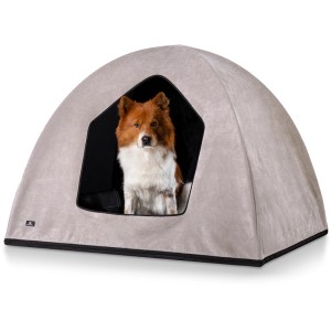 Beige Knuffelwuff Hundehöhle Yucatan Velours (M-L, 90x70x70cm) mit Hund im Eingang.