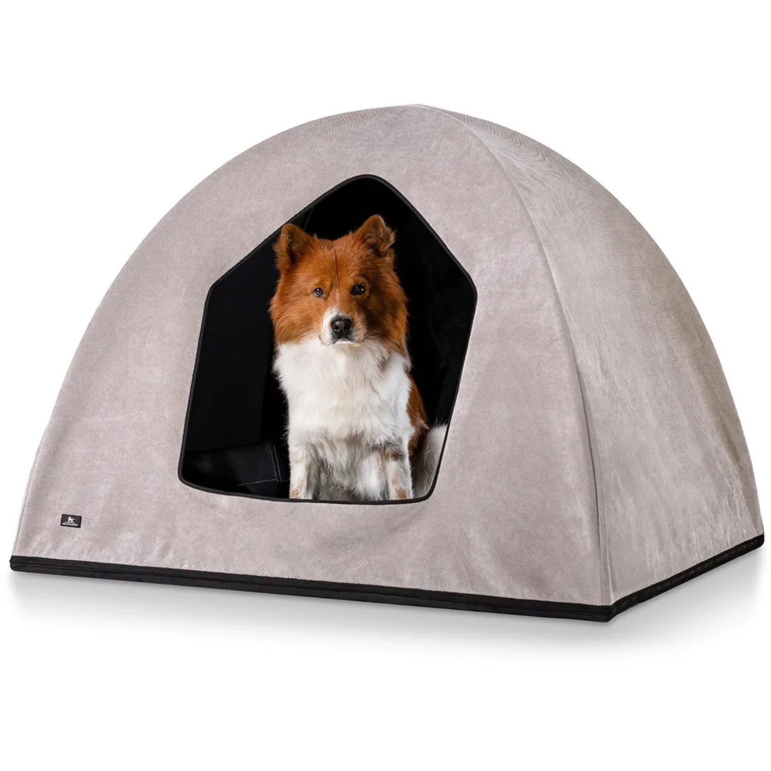 Beige Knuffelwuff Hundehöhle Yucatan Velours (M-L, 90x70x70cm) mit Hund im Eingang.