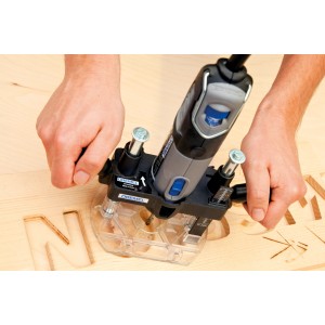 Dremel Oberfräsenvorsatz 335 JA im Einsatz beim Fräsen von Buchstaben in Holz.