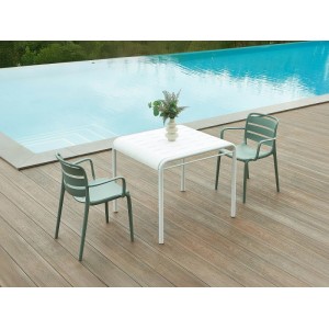 Weißer Vente-unique Gartentisch Moah 90.5 cm auf Holzterrasse mit Stühlen am Pool.