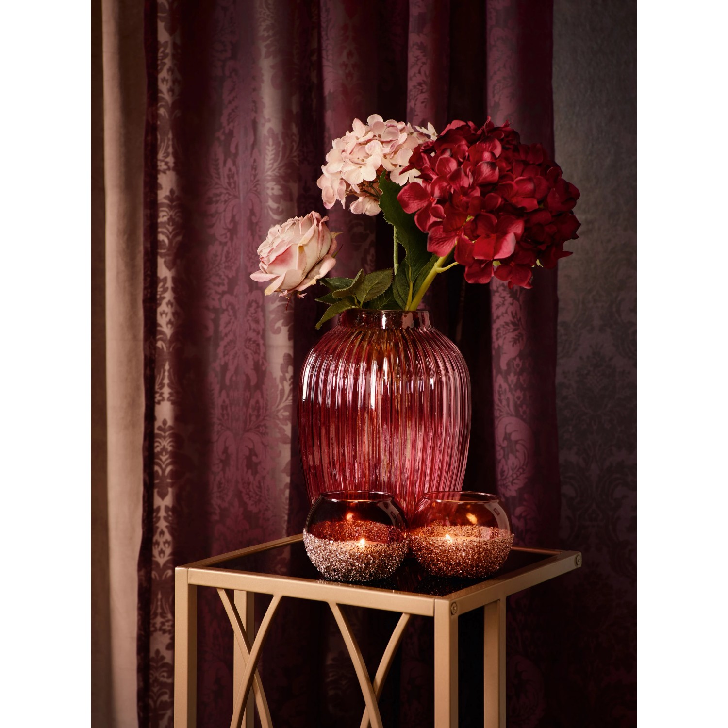 Kunstpflanze Rose Blush Bordeaux (38 cm) in Vase, mit rosa Blüte und roten Hortensien auf Tisch.