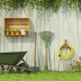 Dunkelbrauner Gusseisen Schlauchhalter mit antikem Design und goldenem Wasserhahn, montiert an einer Holzwand im Garten.