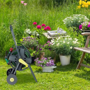 Grau-gelber Relaxdays Gartenschlauchwagen aus Stahl mit grüner Schlauchtrommel, Kurbel und Rädern im Garten.