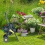Grau-gelber Relaxdays Gartenschlauchwagen aus Stahl mit grüner Schlauchtrommel, Kurbel und Rädern im Garten.