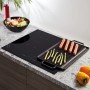 Schwarzes Pyramis Induktionskochfeld PHI63432FMB mit Grillplatte, Würstchen und Spargel.