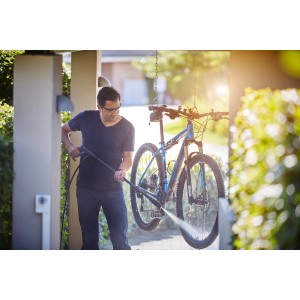Mann reinigt Fahrrad mit Nilfisk Hochdruckreiniger C 110.7-5 X-tra.