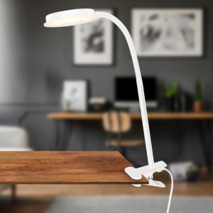 Weiße Briloner LED-Klemmleuchte mit schwenkbarem Kopf und Lichtkante am Tisch befestigt.