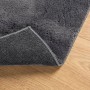 Anthrazitfarbener Kurzflor-Teppich mit weicher Oberfläche und rutschfester Unterseite auf Holz. Waschbar.