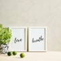 Helle Vliestapete in Putzoptik mit zwei weißen Bilderrahmen, einer mit "Love", einer mit "Breathe".