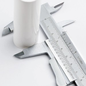 Weiße Orion Lightstyle Kerzenhülse E14 mit Messschieber zur Größenmessung.