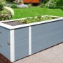 Graues Weka Hochbeet mit Schrank und Bepflanzung im Garten.