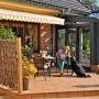 T & J Haselnusszaun Pepe (120x180cm) als Sichtschutz auf einer Terrasse mit Frau und Hund.