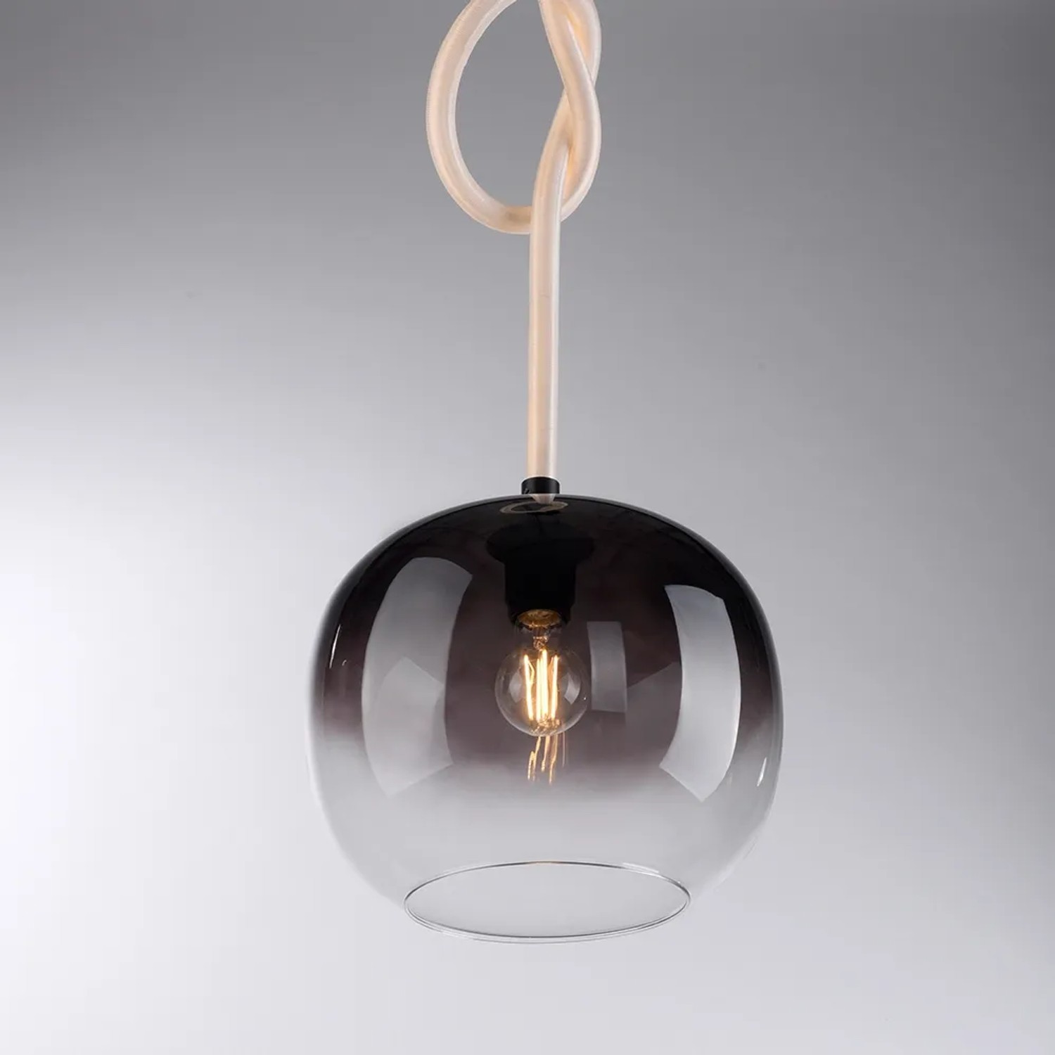 Schwarze Paul Neuhaus LED-Pendelleuchte Luma mit rauchfarbenem Glas und dekorativem Seil.