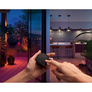 Philips Hue Tap Dial Schalter in Schwarz wird bedient, smarte Lichtsteuerung im Haus und Garten.