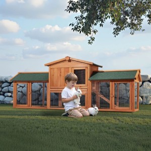 Großer Wiltec XXL Hasenstall aus Holz mit grünem Dach, Kind spielt mit Kaninchen auf Gras. Ideal als Freilaufgehege für Nagerställe.