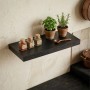 Schwarzes Relaxdays Wandregal aus MDF mit Gewürzen und Pflanzen in einer Küche. Modernes Schweberegal für Deko.