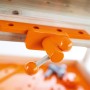 Orangefarbener Schraubstock an der OBI Kinderwerkbank aus Holz, Detailansicht für kleine Handwerker.