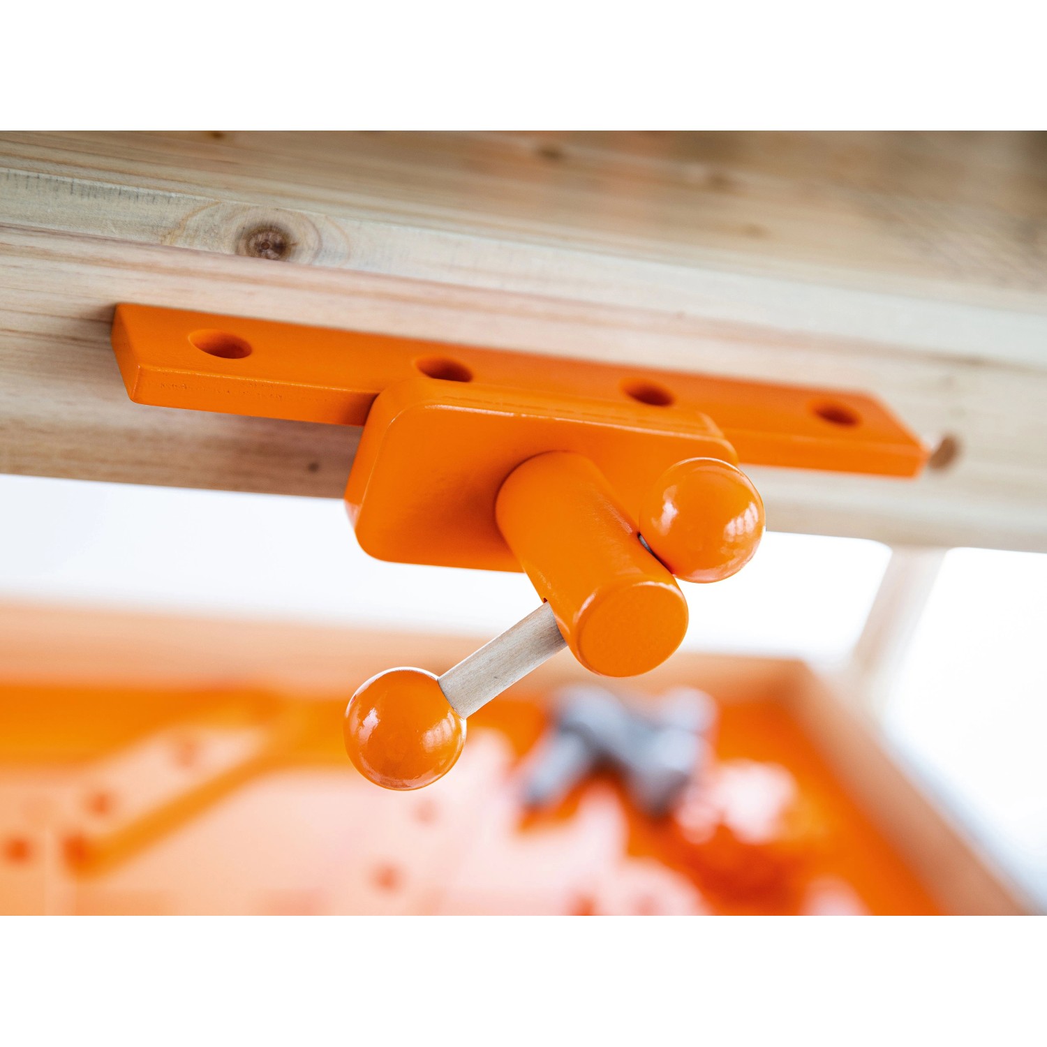 Orangefarbener Schraubstock an der OBI Kinderwerkbank aus Holz, Detailansicht für kleine Handwerker.