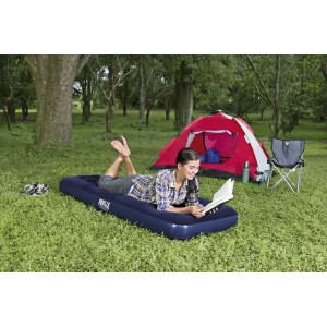 Frau liest auf blauem Single-Luftbett (185x76x22cm) beim Camping. Zelt und Stuhl im Hintergrund.