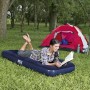 Frau liest auf blauem Single-Luftbett (185x76x22cm) beim Camping. Zelt und Stuhl im Hintergrund.