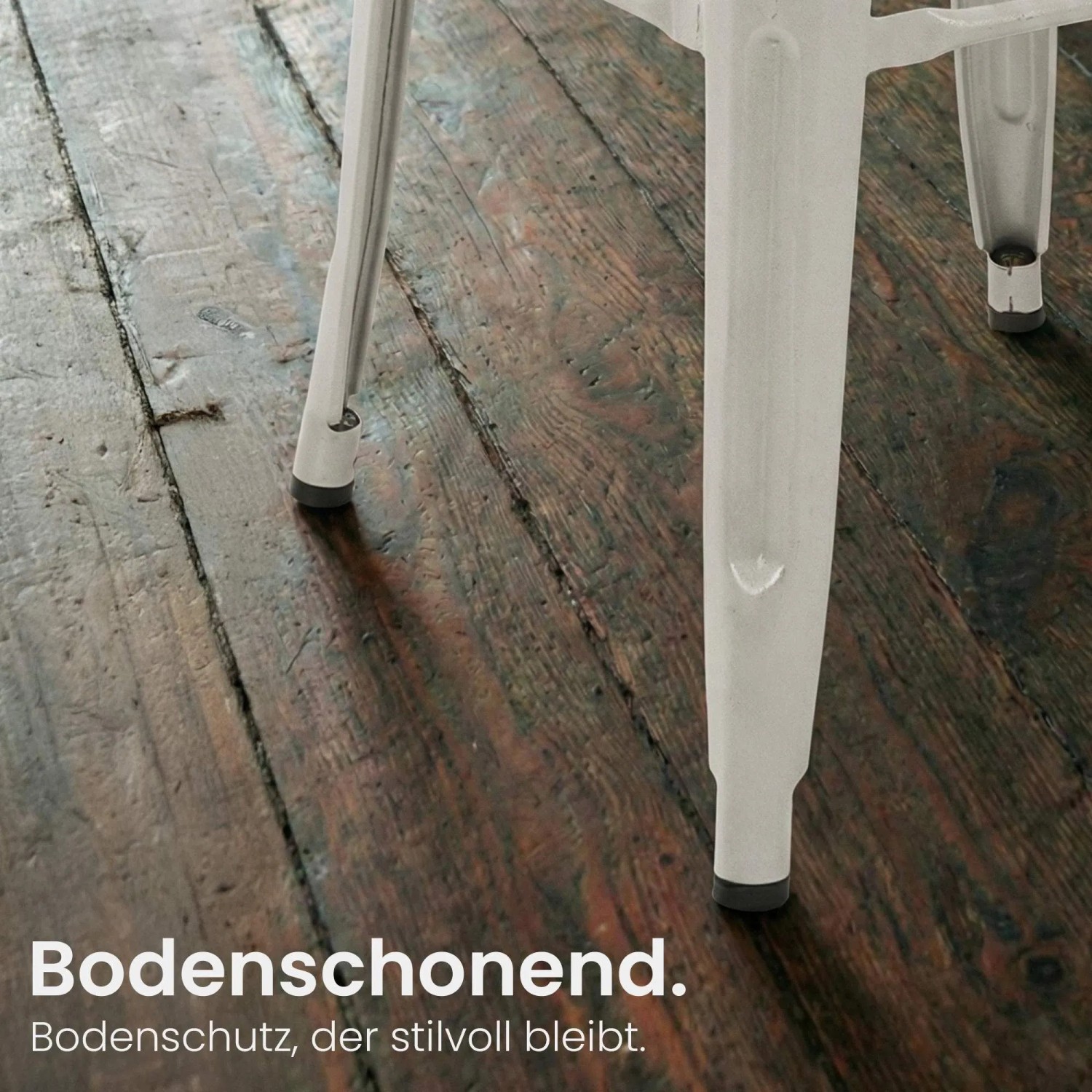 Silbernes Metallbein eines Mason Barhockers mit schwarzem Bodenschutz auf dunklem Holzboden.
