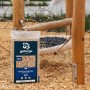 Galamio Holzhackschnitzel Fallschutz 60l auf Spielplatzboden. Helle Holzspäne, dunkles Etikett. Ideal für Spielbereiche.