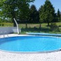 Runder Summer Fun Stahlwandpool BAHRAIN (Ø 350x150 cm) mit Leiter und blauem Wasser im Garten.
