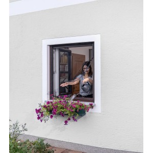 Frau gießt Blumen durch Windhager Insektenschutz Magnetvorhang, anthrazit, 130x150 cm.