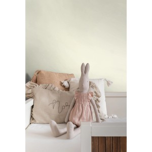 ESTAhome matte Wandfarbe Crême-Weiß (2L) an Wand mit Deko-Kissen und Stofftier.