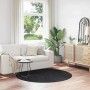 Runder, dunkelgrauer Shaggy-Teppich mit Anti-Rutsch-Basis auf Holzboden im Wohnzimmer. Hochflorteppich.