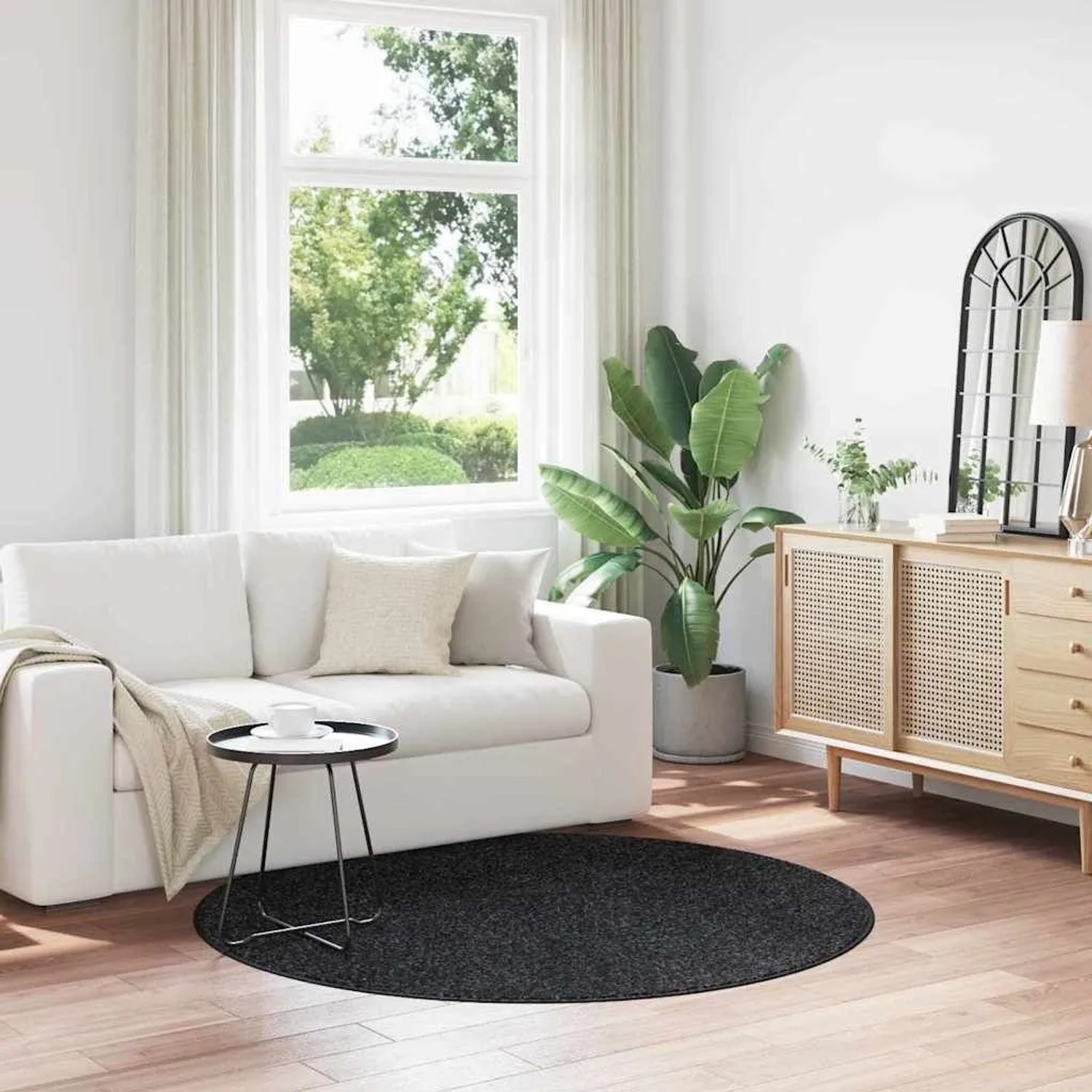 Runder, dunkelgrauer Shaggy-Teppich mit Anti-Rutsch-Basis auf Holzboden im Wohnzimmer. Hochflorteppich.
