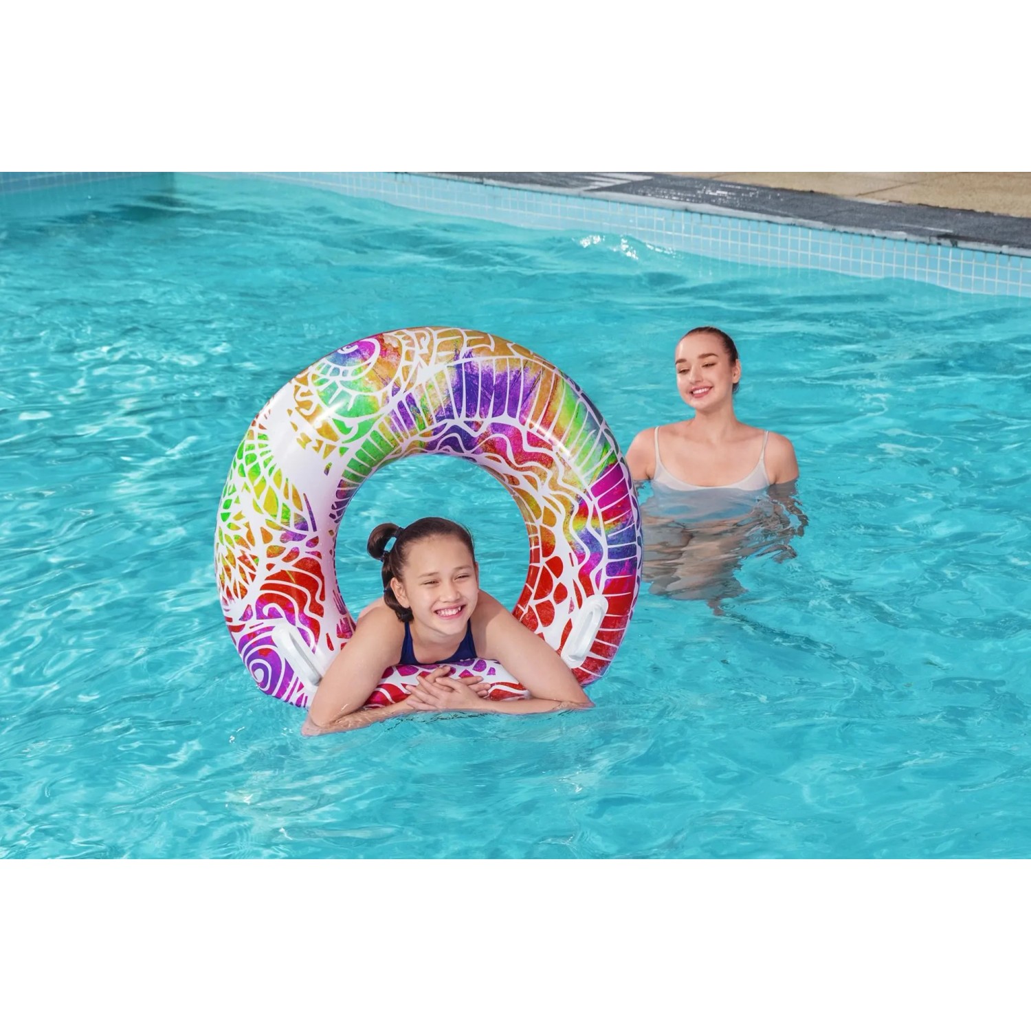 Mädchen schwimmt mit buntem Bestway Schwimmring Summer Swirl im Pool.