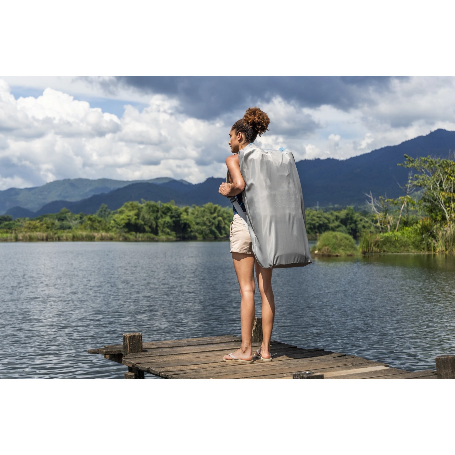 Frau mit Bestway SUP Board-Set Oceana im Rucksack am See.