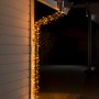 Konstsmide Micro LED Lichterkette mit 800 bernsteinfarbenen Dioden am Hausdach.