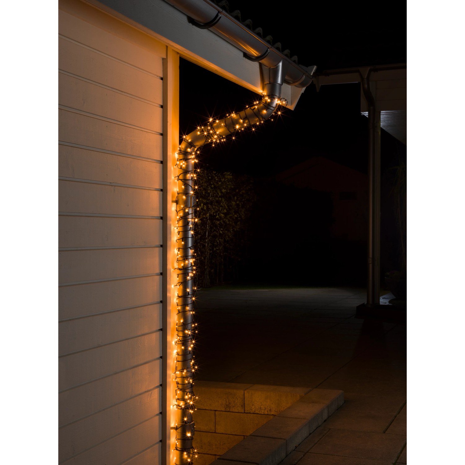 Konstsmide Micro LED Lichterkette mit 800 bernsteinfarbenen Dioden am Hausdach.