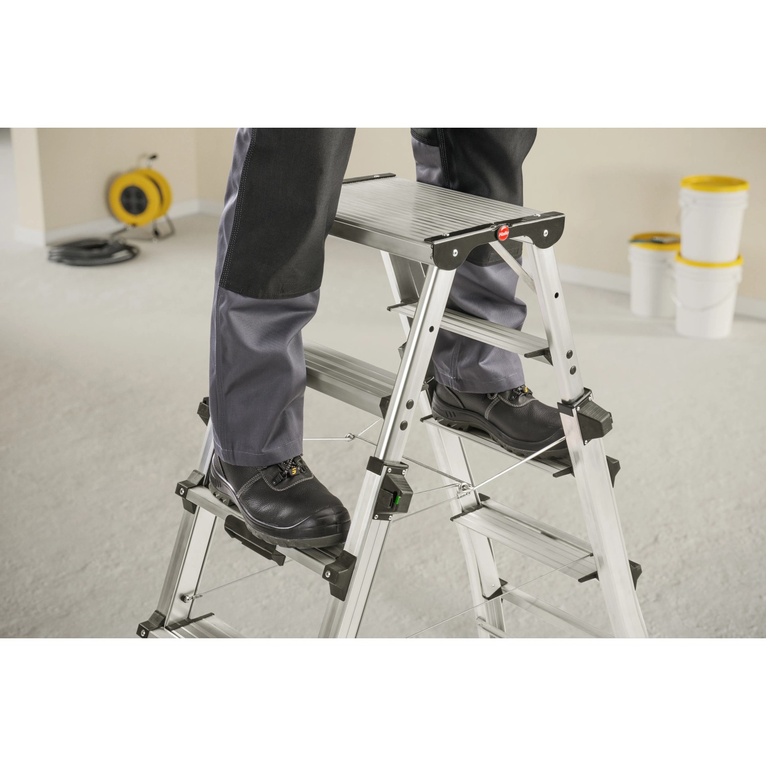 Hailo Teleskop-Doppelstufenleiter D100 TL TopLine aus Aluminium mit Person auf Stufe.